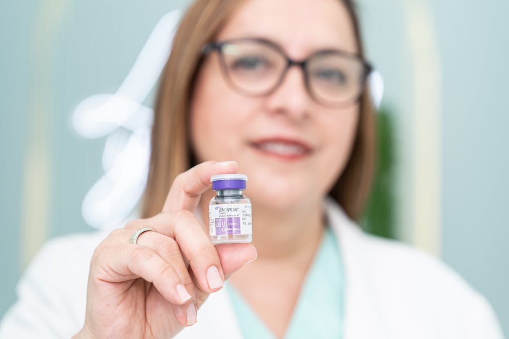 A woman holding a Botox vial, highlighting aesthetic medical cosmetics and beauty treatment.