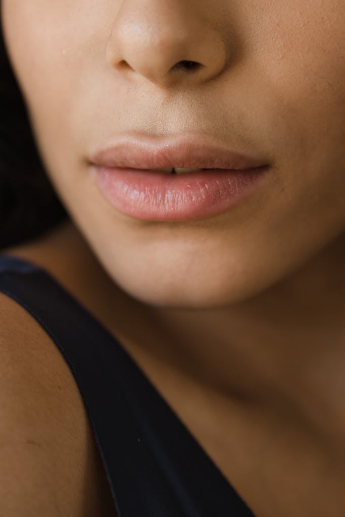 Close-up image of a woman's lips showcasing smooth and healthy skin tone.