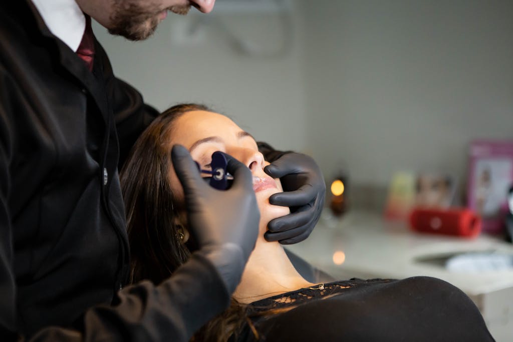 Close-up of a cosmetologist conducting a facial procedure indoors, emphasizing self-care and beauty.